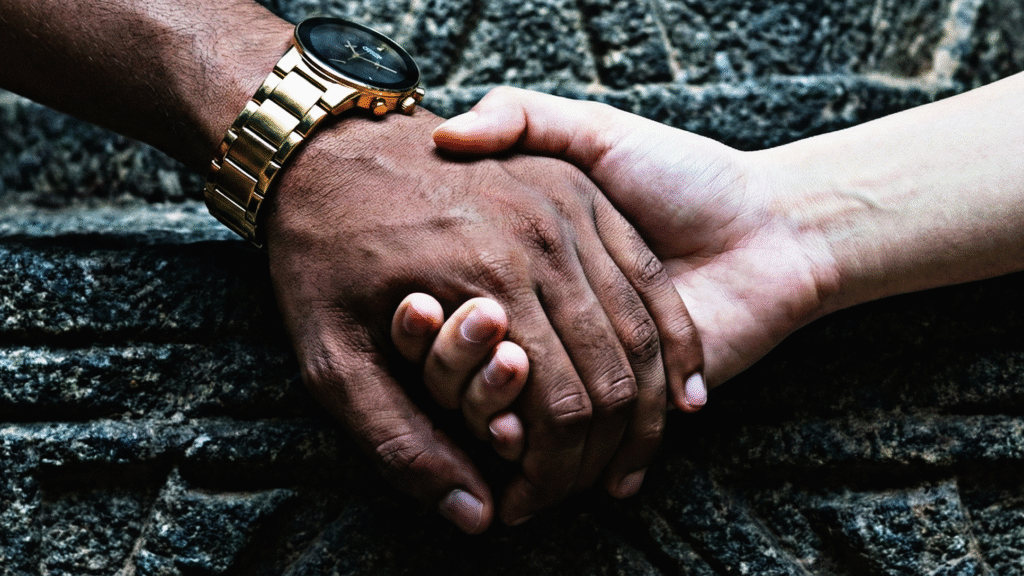 Kesava Chandra’s hand clasping the hand of an unidentified woman on a stone surface.